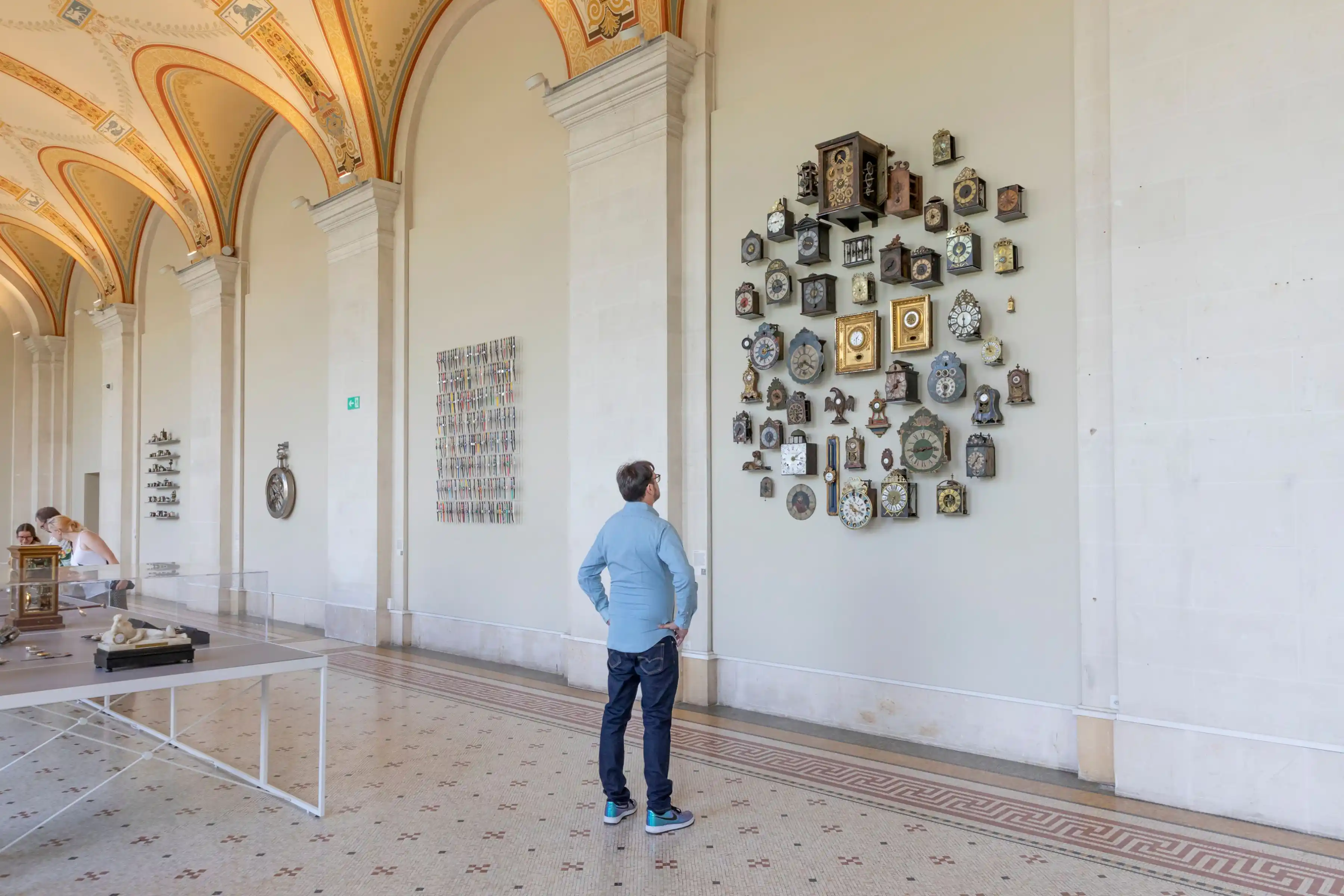 A person admiring the antique clocks hung on a wall in Geneva’s Museum of Art and History, which comes under free museums with Swiss Travel Pass