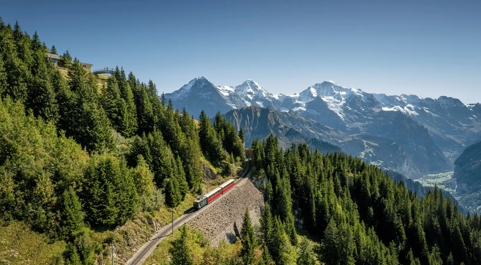 Red panoramic train winding through lush green forests and mountains in Switzerland, demonstrating why SWISStours is the Best place to buy swiss travel pass for scenic rail journeys.