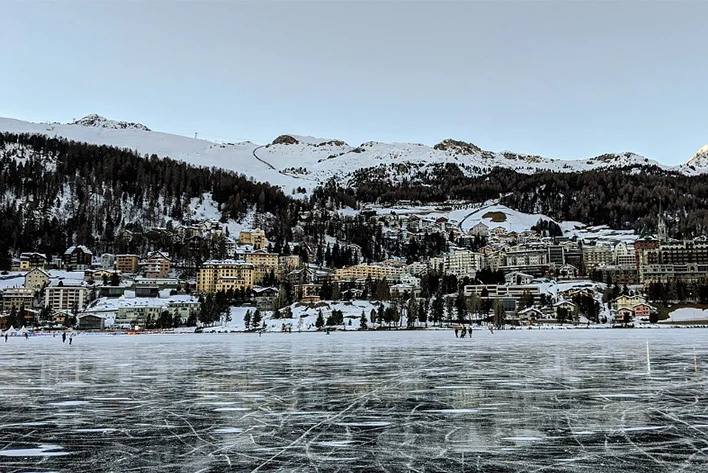 A body of water with Saint Moritz Town in the background