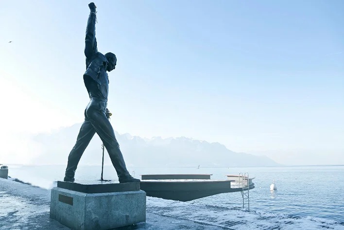 Gray Metal Statue of Man Raising Hand Near Dock in Montreux, Switzerland