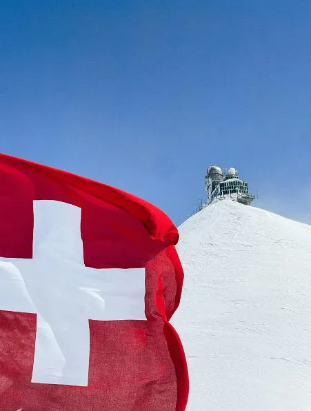 The Swiss flag hoisted proudly near the Sphinx Observatory on Jungfrau Mountain, high in the Swiss Alps.