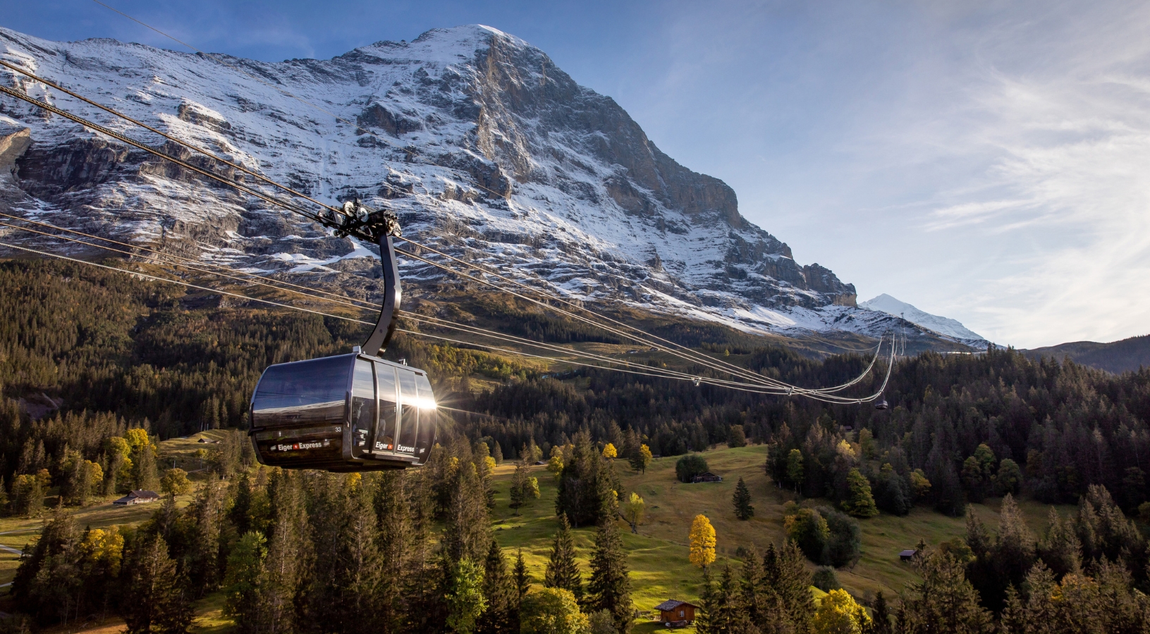 The Eiger Express tricable gondola ascending from Grindelwald Terminal towards Jungfraujoch, with the Eiger north face and alpine meadows below