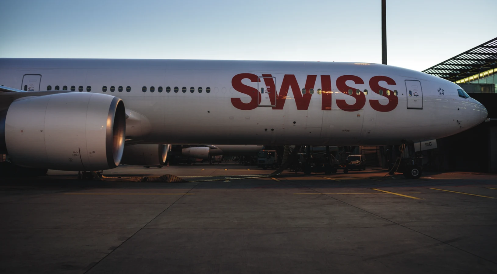 A SWISS aircraft at Zurich Airport, a main gateway for nonstop flights from the USA to Switzerland, with the Swiss Alps in the background