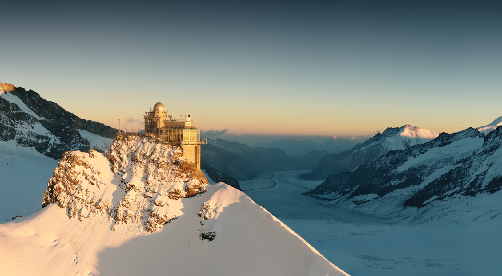 Visitors on the Sphinx Observation Deck at Jungfraujoch, Top of Europe, looking out over the UNESCO-listed Aletsch Glacier and surrounding 4,000-metre Swiss Alps at 3,571 metres
